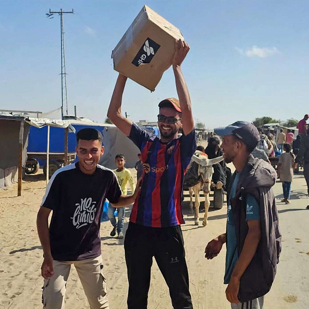 עזתים עם חבילות הסיוע ההומניטרי שקיבלו במתחם החלוקה החדש באזור רפיח | AFP עזתים עם חבילות הסיוע ההומניטרי שקיבלו במתחם החלוקה החדש באזור רפיח | AFP