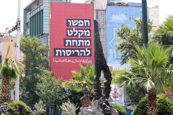 עם כלביא: "חפשו מקלט מתחת להריסות", שלט חוצות בטהרן | AFP עם כלביא: "חפשו מקלט מתחת להריסות", שלט חוצות בטהרן | AFP