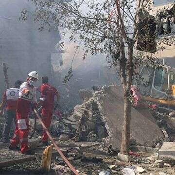 עם כלביא: מתנדבים של הסהר האדום האיראני עובדים בשכונה בטהרן שנפגעה מתקיפה ישראלית | AFP