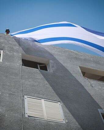 דגל ישראל מונף על בית שנפגע מטיל איראני | דוד כהן - פלאש 90