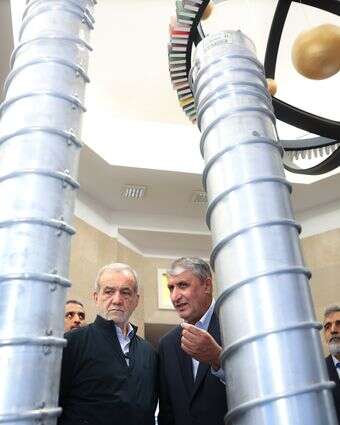 נשיא איראן מסעוד פזשקיאן (שני מימין) וראש ארגון האטום האיראני מוחמד אסלאמי (מימין) בעת ביקורם בתערוכת הישגים גרעיניים במהלך טקס לציון יום הטכנולוגיה האטומית של איראן בטהרן | EPA