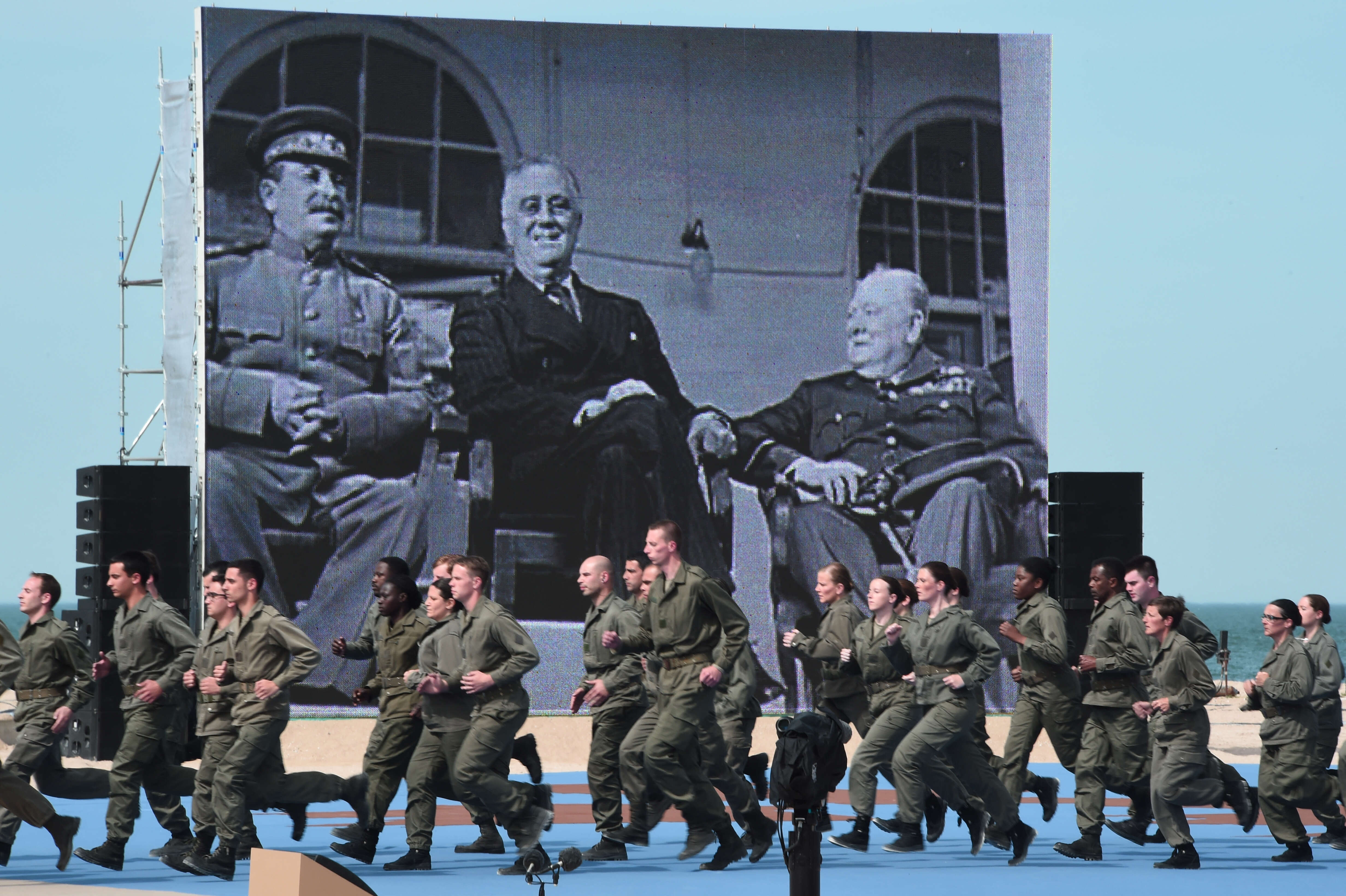 טקס הזיכרון הבינלאומי ליום הפלישה לנורמנדי, 2014 . ברקע נראית תמונתם של צ'רצ'יל, רוזוולט וסטלין | AFP טקס הזיכרון הבינלאומי ליום הפלישה לנורמנדי, 2014 . ברקע נראית תמונתם של צ'רצ'יל, רוזוולט וסטלין | AFP