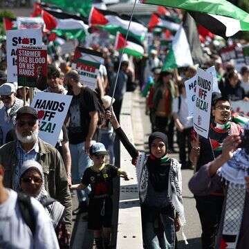 פרו-פלסטינים מנופפים בדגלי פלסטין כשהם צועדים על פני גשר ווטרלו במרכז לונדון | AFP