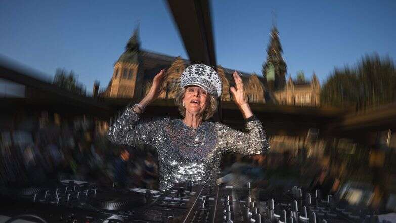 די.ג'יי גלוריה | 81-year-old Madelein Mansson, aka DJ Gloria, performs at Josefina, an outdoor summer bar and club in Stockholm, Sweden, on July 18, 2025. She drops the beat and gets her groove on, spinning discs like a pro as her head-to-toe sequins twinkle under the lights: at age 81, DJ Gloria is filling dancefloors across Sweden. (Photo by Jonathan NACKSTRAND / AFP) / TO GO WITH AFP STORY BY PIA OHLIN די.ג'יי גלוריה | 81-year-old Madelein Mansson, aka DJ Gloria, performs at Josefina, an outdoor summer bar and club in Stockholm, Sweden, on July 18, 2025. She drops the beat and gets her groove on, spinning discs like a pro as her head-to-toe sequins twinkle under the lights: at age 81, DJ Gloria is filling dancefloors across Sweden. (Photo by Jonathan NACKSTRAND / AFP) / TO GO WITH AFP STORY BY PIA OHLIN