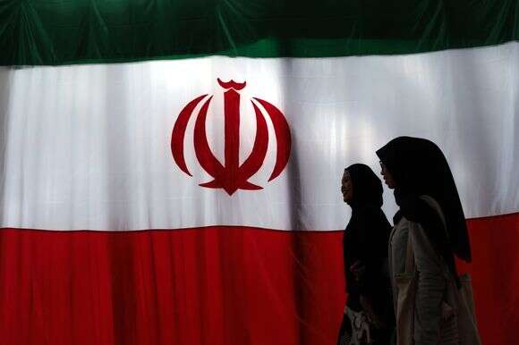 נשים חולפות על פני דגל איראני | EPA