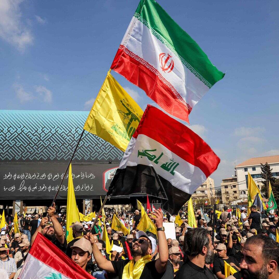 תומכי התנועה השיעית הלבנונית חיזבאללה מנופפים בדגלי הארגון, איראן ועיראק במהלך טקס לציון יום השנה הראשון להתנקשות בישראל במנהיגם הוותיק חסן נסראללה בפרברים הדרומיים של ביירות ב-27 בספטמבר 2025 | AFP