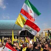 תומכי התנועה השיעית הלבנונית חיזבאללה מנופפים בדגלי הארגון, איראן ועיראק במהלך טקס לציון יום השנה הראשון להתנקשות בישראל במנהיגם הוותיק חסן נסראללה בפרברים הדרומיים של ביירות ב-27 בספטמבר 2025 | AFP