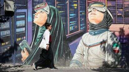 אישה איראנית חולפת על פני ציור קיר ברחוב בטהרן | EPA אישה איראנית חולפת על פני ציור קיר ברחוב בטהרן | EPA