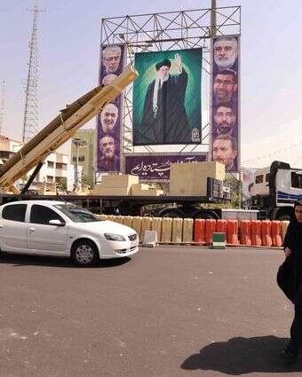 טיל בליסטי ח'ייבר שקאן שהושבת לצד תמונה של המנהיג העליון, האייתוללה עלי חמינאי, בכיכר בחרסטאן בטהרן, כחלק מתערוכה לציון "שבוע ההגנה הקדושה" לציון מלחמת איראן-עיראק, ספטמבר 2025 | AFP