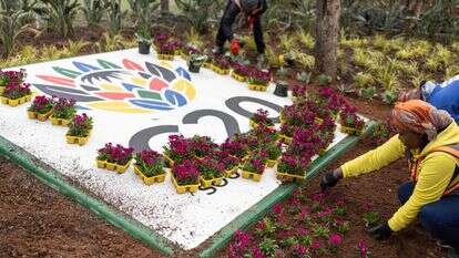 עובדים שותלים פרחים ליד לוגו של ה-G20 מחוץ למרכז התערוכות NASREC ביוהנסבורג ב-4 בנובמבר 2025, שם תתקיים פסגת ה-G20 הקרובה | AFP