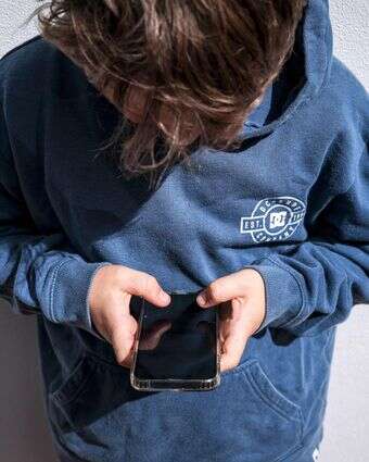 ילד משחק בטלפון הסלולרי שלו | AFP