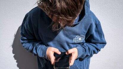 ילד משחק בטלפון הסלולרי שלו | AFP