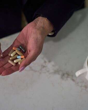 רות וילסון, שחולה בזאבת, נוטלת את תרופות המרשם והתוספים שלה לפני שיוצאת לעבודה | AP Photo/David Goldman רות וילסון, שחולה בזאבת, נוטלת את תרופות המרשם והתוספים שלה לפני שיוצאת לעבודה | AP Photo/David Goldman