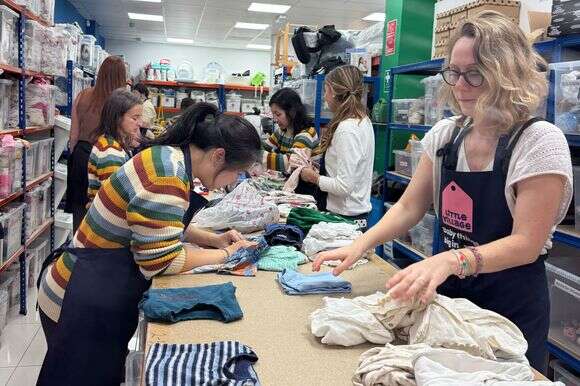מתנדבים ממיינים בגדי תינוקות בליטל וילג', ארגון צדקה שהחל בשנה שעברה לספק למחלקות יולדות ברחבי לונדון מצרכים חיוניים לאמהות חדשות | Karla Adam/The Washington Post