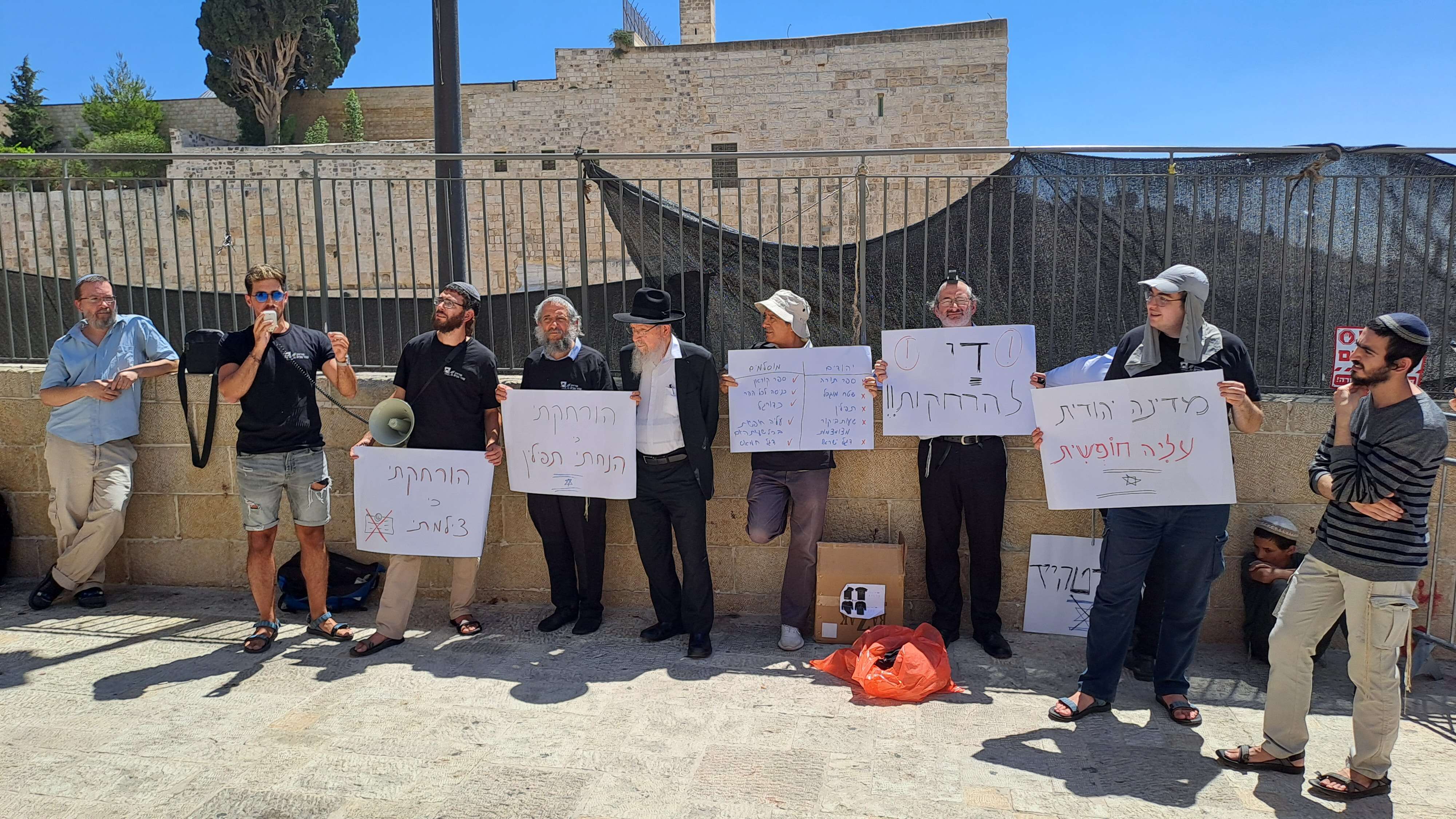 מיכאל פואה (השלישי משמאל) בהפגנת מחאה על ריבוי ההרחקות מהר הבית, יולי 2025 | ללא מיכאל פואה (השלישי משמאל) בהפגנת מחאה על ריבוי ההרחקות מהר הבית, יולי 2025 | ללא