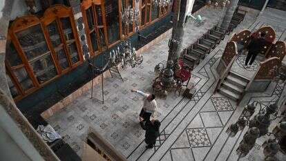 הנרי חמרה עומד יחד עם מדורה סתחי בתוך בית הכנסת פאראנג' בדמשק | Henry Hamra, one of the founding members of a Jewish-Syrian organisation that plans to work to return properties confiscated under previous Syrian governments, stands with Madora Sattahi inside the Faranj synagogue in Damascus on December 10, 2025. Syrian authorities on December 10 granted a licence to a Jewish-Syrian organisation that plans to work to return properties confiscated under previous governments, one of its founders said. Since Islamist-led forces toppled long-time ruler Bashar al-Assad in December last year after nearly 14 years of civil war, the country's dwindling Jewish community has begun welcoming back Syrian Jews who had emigrated and the new authorities have made overtures towards the minority group. (Photo by LOUAI BESHARA / AFP) הנרי חמרה עומד יחד עם מדורה סתחי בתוך בית הכנסת פאראנג' בדמשק | Henry Hamra, one of the founding members of a Jewish-Syrian organisation that plans to work to return properties confiscated under previous Syrian governments, stands with Madora Sattahi inside the Faranj synagogue in Damascus on December 10, 2025. Syrian authorities on December 10 granted a licence to a Jewish-Syrian organisation that plans to work to return properties confiscated under previous governments, one of its founders said. Since Islamist-led forces toppled long-time ruler Bashar al-Assad in December last year after nearly 14 years of civil war, the country's dwindling Jewish community has begun welcoming back Syrian Jews who had emigrated and the new authorities have made overtures towards the minority group. (Photo by LOUAI BESHARA / AFP)