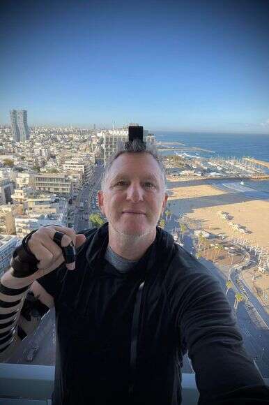 "במלחמה גיליתי את הנפש היהודית שלי". רפפורט מניח תפילין על רקע תל־אביב | באדיבות המצולם "במלחמה גיליתי את הנפש היהודית שלי". רפפורט מניח תפילין על רקע תל־אביב | באדיבות המצולם