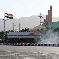 מכלית נפט חולפת על פני דגל תימן מתנופף | EPA/YAHYA ARHAB