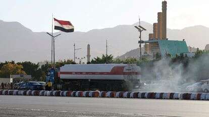 מכלית נפט חולפת על פני דגל תימן מתנופף | EPA/YAHYA ARHAB