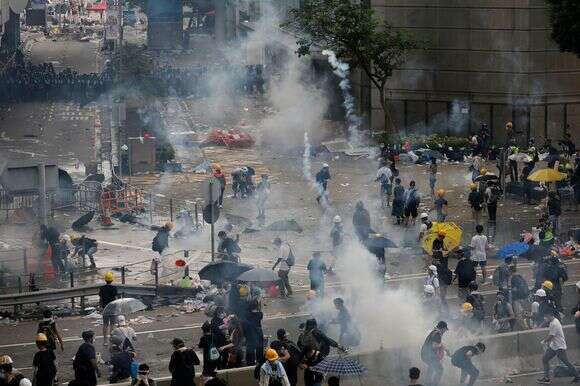 משטרת המהומות פועלת לפיזור מפגינים באמצעות גז מדמיע מחוץ למועצה המחוקקת, 12 ביוני 2019, בהונג קונג | AP/וינסנט יו