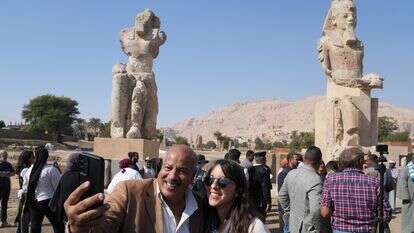 מבקרים מצטלמים עם שני פסלי בהט ענקיים שהורכבו מחדש של פרעה אמנחותפ השלישי, בעיר לוקסור שבדרום מצרים | AP Photo/Amr Nabil