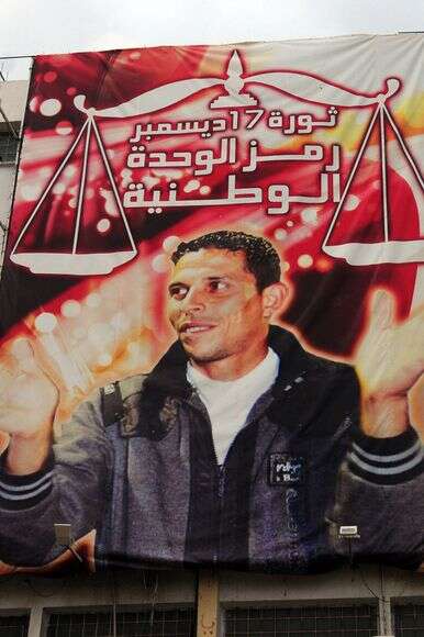 שלט עם תמונתו של מוחמד בועזיז, שהצית את עצמו ב-2011 וגרם למהפכות האביב הערבי | AP שלט עם תמונתו של מוחמד בועזיז, שהצית את עצמו ב-2011 וגרם למהפכות האביב הערבי | AP