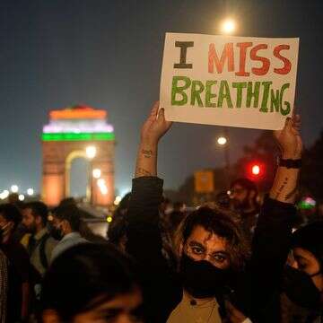 אדם מחזיק שלט במהלך מחאה נגד מה שהם כינו חוסר הפעולה של הממשלה למאבק בזיהום אוויר בניו דלהי, הודו, 9 בנובמבר 2025 | AP Photo/Manish Swarup