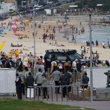 אנשי אבטחה מתאספים ליד שער בחוף בונדי | AP/מארק בייקר