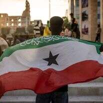 ישות דמוקרטית ויציבה בחלק בלתי יציב של העולם. צעיר בבירה הרגייסה מניף את דגל סומלילנד | איי.אף.פי ישות דמוקרטית ויציבה בחלק בלתי יציב של העולם. צעיר בבירה הרגייסה מניף את דגל סומלילנד | איי.אף.פי