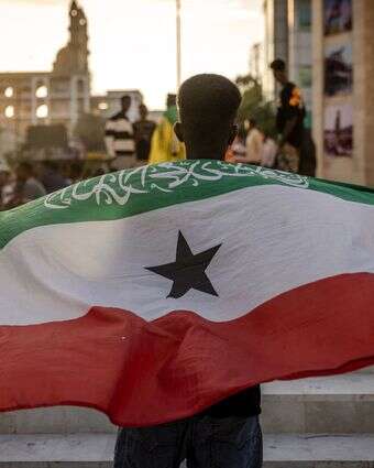 ישות דמוקרטית ויציבה בחלק בלתי יציב של העולם. צעיר בבירה הרגייסה מניף את דגל סומלילנד | איי.אף.פי ישות דמוקרטית ויציבה בחלק בלתי יציב של העולם. צעיר בבירה הרגייסה מניף את דגל סומלילנד | איי.אף.פי