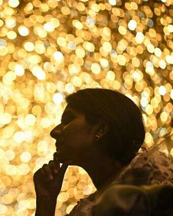 אישה מביטה בקניון פיניקס אוף אסיה המעוטר בתאורה לקראת פסטיבל חג המולד בבנגלור | AFP אישה מביטה בקניון פיניקס אוף אסיה המעוטר בתאורה לקראת פסטיבל חג המולד בבנגלור | AFP