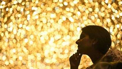 אישה מביטה בקניון פיניקס אוף אסיה המעוטר בתאורה לקראת פסטיבל חג המולד בבנגלור | AFP