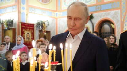 נשיא רוסיה ולדימיר פוטין בכנסייה הממוקמת בשטח יחידה צבאית במחוז מוסקבה | Vyacheslav PROKOFYEV / POOL / AFP