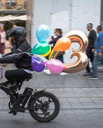 שליח נושא בלונים רוכב על אופניו ברחוב יפו במרכז העיר ירושלים | Olivier Fitoussi/Flash90