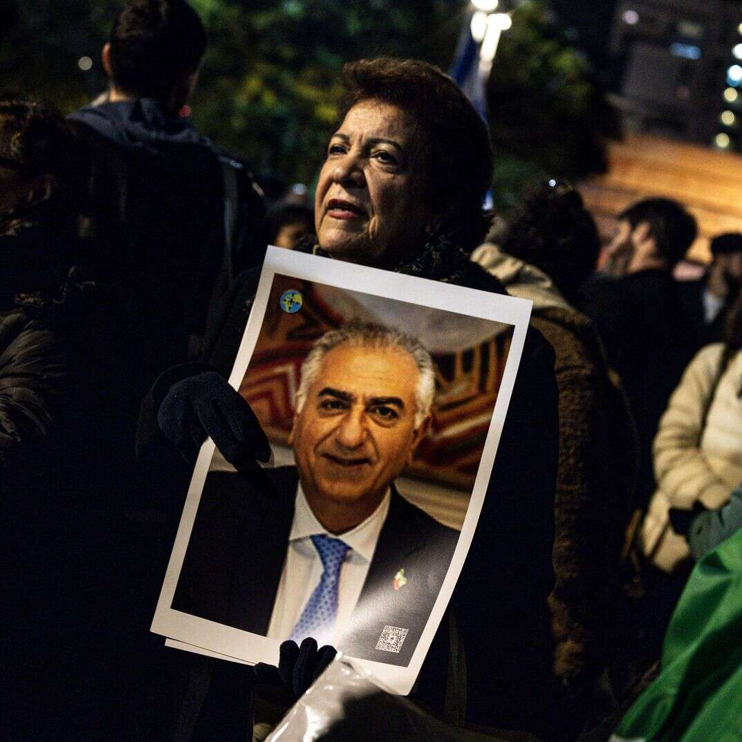 ה מחזיקה דיוקן של בנו של השאה האחרון של איראן, מוחמד רזא פהלווי, במהלך הפגנה בסולידריות עם מפגינים איראנים | ג'ון וסלס / AFP