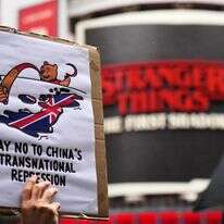 מפגינים אוחזים במטריות, שלטים ודגלים בהפגנה נגד ההצעה לבניית שגרירות סינית חדשה | AP