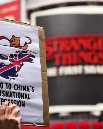 מפגינים אוחזים במטריות, שלטים ודגלים בהפגנה נגד ההצעה לבניית שגרירות סינית חדשה | AP