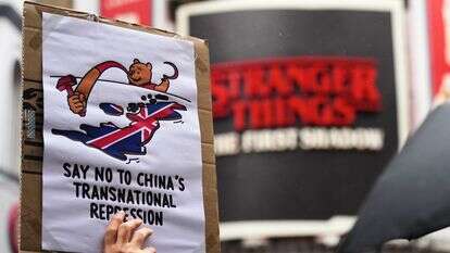 מפגינים אוחזים במטריות, שלטים ודגלים בהפגנה נגד ההצעה לבניית שגרירות סינית חדשה | AP