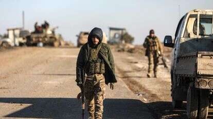 חיילים חולפים על פני מכונית חונה בזמן שכוחות ממשלת סוריה עושים את דרכם לעיר חסכה בצפון מזרח סוריה | AFP