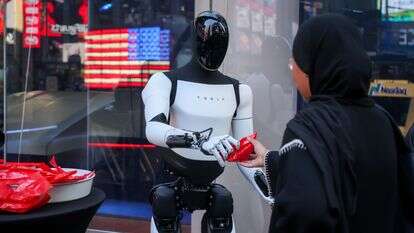 רובוט של טסלה אופטימוס מחלק ממתקים מול בורסת נאסד"ק בניו יורק | מייקל נגל/בלומברג