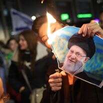 חבר בקהילה הישראלית-איראנית שורף תמונה של המנהיג העליון של איראן, עלי חמינאי, במהלך הפגנה לתמיכה בעם האיראני בחולון | EPA/ABIR SULTAN