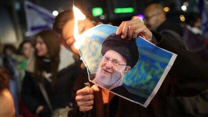 חבר בקהילה הישראלית-איראנית שורף תמונה של המנהיג העליון של איראן, עלי חמינאי, במהלך הפגנה לתמיכה בעם האיראני בחולון | EPA/ABIR SULTAN