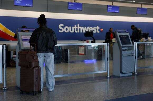 : נוסע של סאות'ווסט איירליינס עושה צ'ק-אין לטיסה בשדה התעופה אוקלנד סן פרנסיסקו ביי | NORTH AMERICA / Getty Images via AFP