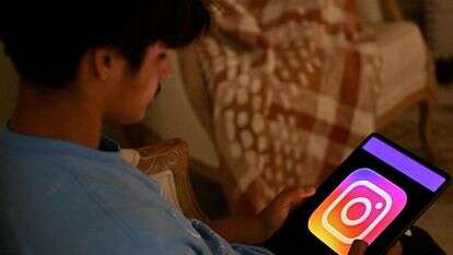 ילד בן 13 מצטלם בביתו כשהוא צופה ברשתות חברתיות בטאבלט שלו בסידני | סעיד חאן / AFP