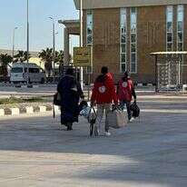 אישה עזתית בדרך לכניסה למעבר רפיח, מלווה באנשי הסהר האדום הפלסטיני | הסהר האדום הפלסטיני