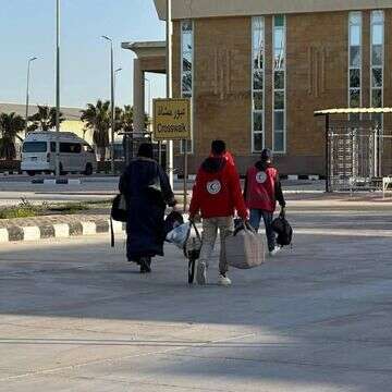 אישה עזתית בדרך לכניסה למעבר רפיח, מלווה באנשי הסהר האדום הפלסטיני | הסהר האדום הפלסטיני