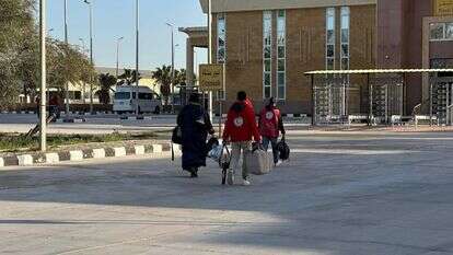 אישה עזתית בדרך לכניסה למעבר רפיח, מלווה באנשי הסהר האדום הפלסטיני | הסהר האדום הפלסטיני