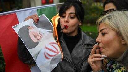 מפגינות שורפות את תמונתו של המנהיג העליון של איראן, עלי חמינאי | AFP