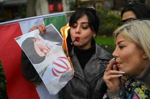 מפגינות שורפות את תמונתו של המנהיג העליון של איראן, עלי חמינאי | AFP מפגינות שורפות את תמונתו של המנהיג העליון של איראן, עלי חמינאי | AFP