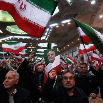 אנשים מנופפים בדגלי איראן בעוד אחד מהם מרים פוסטר של מפקד כוח קודס של משמרות המהפכה האיראניים, הגנרל קאסם סולימאני | AP/Vahid Salemi אנשים מנופפים בדגלי איראן בעוד אחד מהם מרים פוסטר של מפקד כוח קודס של משמרות המהפכה האיראניים, הגנרל קאסם סולימאני | AP/Vahid Salemi